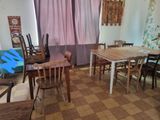 a room with a table, chairs, and a guitar in it