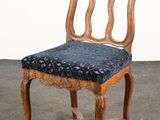 une image représentant une chaise en bois dont l'assise est recouverte d'un tissu bleu