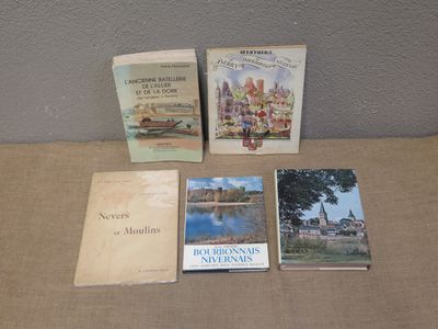 several books are sitting on a table with a wall in the background