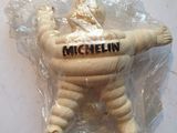 une petite figurine dans un sachet en plastique sur lequel figure un nom