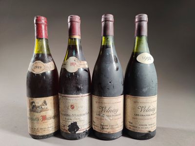 quatre bouteilles de vin sont alignées sur une table