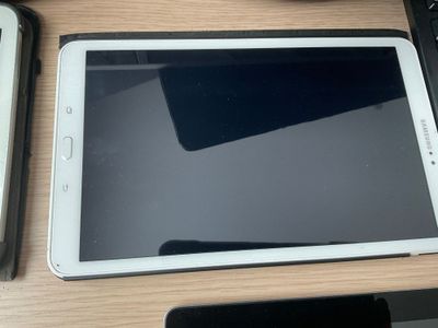 une tablette posée sur un bureau, à côté d'un clavier