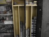 a small cabinet with many cans of paint in it