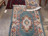 plusieurs tapis et chaises dans une pièce équipée d'une table et de chaises