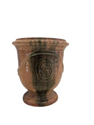 un vase brun posé sur une surface blanche