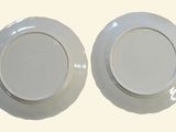 two plates that are sitting on a white surface