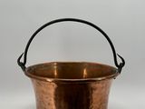 une vieille casserole en cuivre avec une poignée, sur fond blanc
