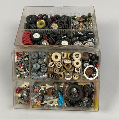 a box of assorted buttons and screws on a white surface