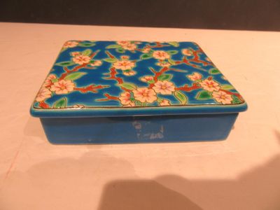 une boîte bleue décorée de fleurs, posée sur une table