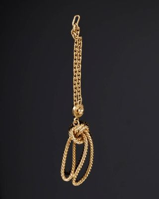 Gros plan sur un collier en or avec un nœud.
