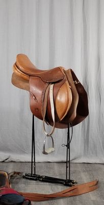 une selle posée sur un support à côté d'une paire de chaussures