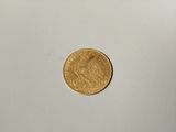 a close up of a gold coin on a white surface
