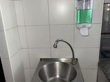 un évier en acier inoxydable dans le coin d'une toilette publique