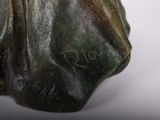 a bronze statue of a dog that is sitting on a table