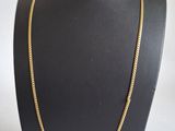 un collier à chaîne en or sur le cou d'un mannequin