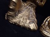 a gold statue of a woman and a gold purse