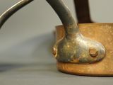 a close up of a pot with a handle on a table