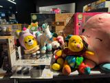 many stuffed animals on a shelf in a store
