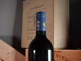 a bottle of wine sitting on a table next to a box of wine