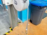 un tuyau fixé sur le mur, à côté d'une poubelle