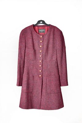 une veste violette suspendue à un cintre sur un mur blanc