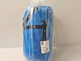 un sac de voyage bleu, emballé dans du plastique, posé sur une table
