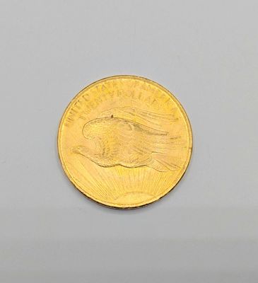 Gros plan sur une pièce d'or ornée d'un oiseau