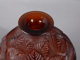 a brown glass vase with a leaf design on it