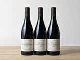 trois bouteilles de vin posées sur une table en bois