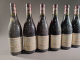 six bottles of wine are lined up in a row on a table