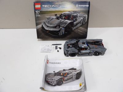a box of lego technics on a table next to a toy car