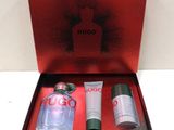 une image représentant une boîte rouge contenant un flacon de parfum et un tube de lotion