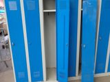 several blue lockers are stacked up in a row in a warehouse