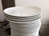 a stack of white plates on a table in a room