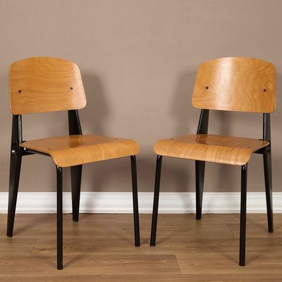 deux chaises en bois assises l'une à côté de l'autre sur un sol en bois dur