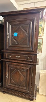 a tall wooden cabinet in the corner of a room