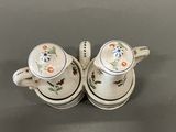 two cups and a saucer sitting on a table
