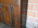 a wooden cabinet that is next to a brick wall