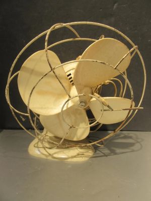 un ventilateur en métal posé sur une table