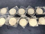 six quarters of gold coins in plastic bags on a black surface