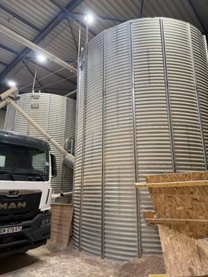 un camion garé devant un grand silo