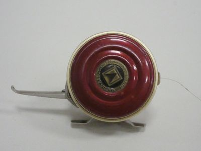 an image of a red and gold fishing reel