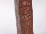 an old book with writing on it sitting on a white surface