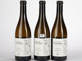 trois bouteilles de vin posées l'une à côté de l'autre sur une table