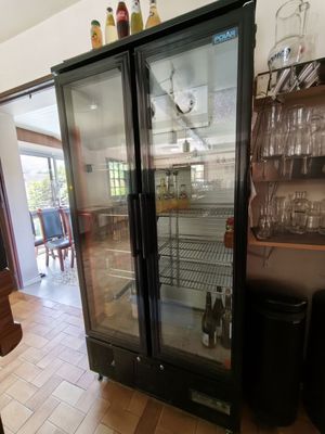 a glass door refrigerator in the middle of a kitchen