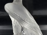 crystal figurine of an eagle sitting on a rock on a black surface