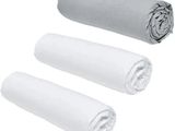 trois rouleaux de serviettes blanches posés les uns à côté des autres sur une surface blanche