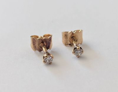 une paire de boucles d'oreilles en or et diamants sur fond blanc