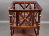 a small wooden table with a magazine rack on it