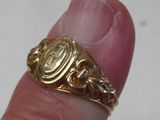 une bague en or au doigt, ornée d'une croix